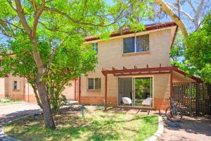 ein Haus mit zwei weißen Stühlen und einem Baum in der Unterkunft Marsfield 5 bed Townhouse near Macquarie Uni FreeP in Sydney