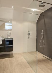 a bathroom with a shower with a glass door at Hotel Wapen van Delden in Delden
