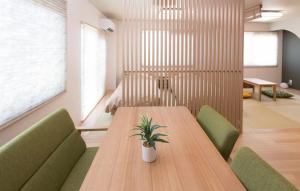 una sala de conferencias con mesa de madera y sillas verdes en PAL-TERRACE FUJIMI, en Tokio