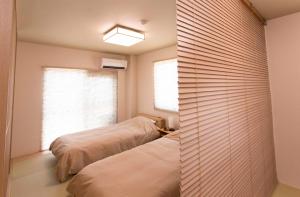 een slaapkamer met 2 bedden en een raam bij PAL-TERRACE FUJIMI in Tokyo