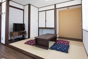 een woonkamer met een bed en een televisie bij PAL-TERRACE FUJIMI in Tokyo