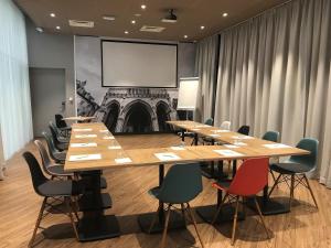 a conference room with tables and chairs and a screen at Hotel ibis Dijon Centre Clemenceau in Dijon