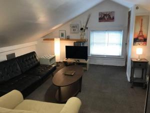 a living room with a couch and a table at Cozy Alcove Studio Apt w Outdoor deck w NYC Views in Jersey City