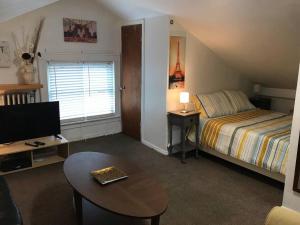 a bedroom with a bed and a tv and a table at Cozy Alcove Studio Apt w Outdoor deck w NYC Views in Jersey City