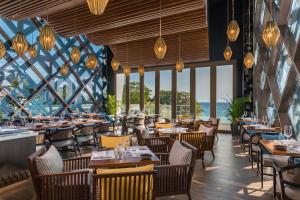 um restaurante com mesas e cadeiras e janelas grandes em Crimson Resort and Spa Boracay em Boracay