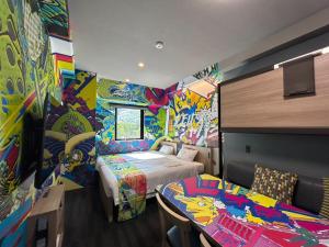 a bedroom with a bed and a colorful wall at MONday Apart Asakusabashi Akihabara in Tokyo