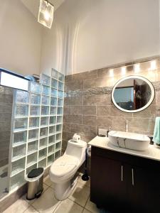 bagno con servizi igienici, lavandino e specchio di Gated Single Storey Condo a Coco
