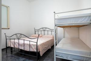 a bedroom with two bunk beds with pink sheets at Appartamento Acquadolce n 2 in Torre Ovo