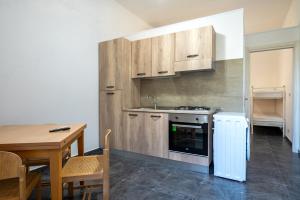 a kitchen with a table and a sink and a stove at Appartamento Acquadolce n 2 in Torre Ovo +22 photos