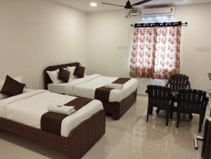 um quarto com 2 camas, uma mesa e cadeiras em HOTEL VIRAT GRAND em Hyderabad