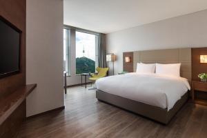 ソウルにあるコートヤード バイ マリオット ソウル 南大門のベッドとテレビが備わるホテルルームです。