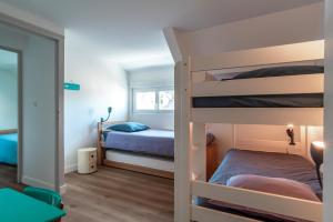 a bedroom with two bunk beds and a mirror at Borgroix - Charmante maison à Belle-Île-en-Mer in Sauzon