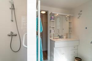 a white bathroom with a shower and a sink at Borgroix - Charmante maison à Belle-Île-en-Mer in Sauzon