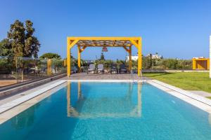 a swimming pool with a gazebo and blue water at Villa Sandi with Private Pool in Hersonissos