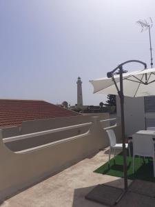 een tafel en stoelen op een dak met een vuurtoren bij Brezza di mare in Punta Secca