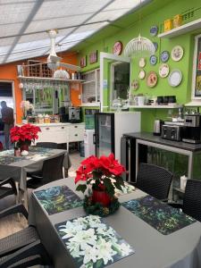 um restaurante com duas mesas com flores vermelhas em Mitchell's Guesthouse em Parow