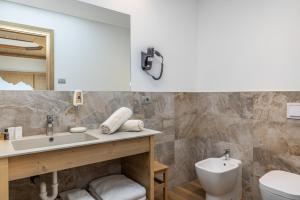 uma casa de banho com um lavatório e um WC em Miraval Hotel em Coredo