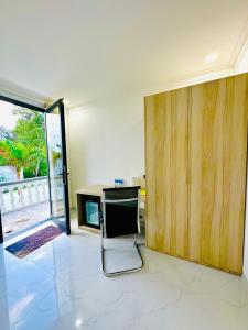 24 Gold Homestay في فان ثيت: غرفة بها مكتب وباب زجاجي منزلق