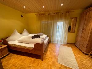 una camera da letto con un letto con lenzuola bianche e una finestra di Ferienhaus Sofia a Urschmitt