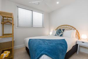a bedroom with a large bed and a window at Sunny Palm Cottage Byron Bay - Brand New in Byron Bay