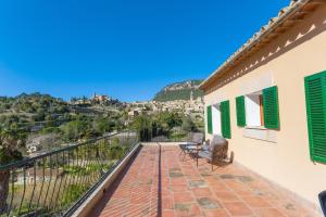 uma varanda de uma casa com persianas verdes em Casa Miranda em Valldemossa