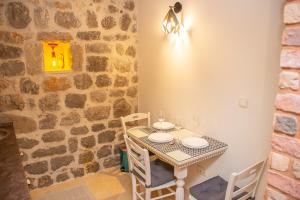 a small table and chairs in a room with a stone wall at Pallazo Uniqato seafront in Kotor
