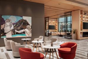 a lobby with tables and chairs and a large painting on the wall at Four Points by Sheraton Istanbul Kagithane in Istanbul
