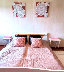 Simpele的住宿－Villa Mummola Neljän makuuhuoneen asunto lähellä jokea，一间卧室配有一张带两张桌子的大型粉红色床
