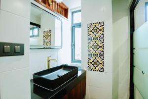 a bathroom with a black sink and a window at WangChang Hotel Chiang Mai โรงแรมวังช้าง เชียงใหม่ in Chiang Mai