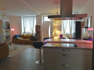 un salon avec une cuisine et un salon avec un canapé dans l'établissement L'Eau Vive, à Dinan