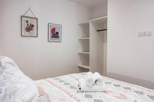 ein weißes Schlafzimmer mit Handtüchern auf dem Bett in der Unterkunft Le Vintage- Gare/centre, tout équipé, refait à neuf, climatisation in Châteauroux