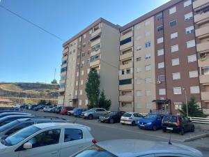 un parcheggio con auto parcheggiate di fronte agli edifici di Apartment Gelić Family a Kumanovo