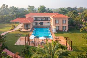 an aerial view of a house with a swimming pool at ama Stays & Trails 25 Farm House, Vedic Village, Kolkata in Kolkata