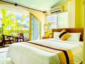 a bedroom with a large bed and a large window at Hải Nam Hotel (Sài Gòn) in Ho Chi Minh City