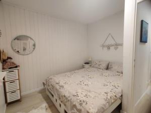 a white bedroom with a bed and a mirror at Apartment Lilija in Bovec