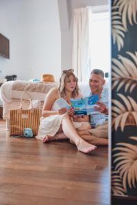 a man and woman sitting on the floor looking at a box at Le Manoir H&ocirc;tel in La Rochelle