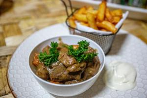 a bowl of food on a plate with french fries at The Asaro Mudmen Tribal Eco Lodge 