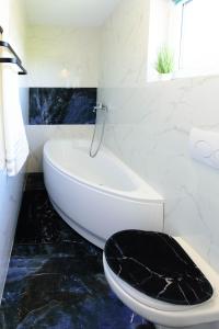 een badkamer met een wit bad en een zwart toilet bij Pokój gościnny 