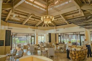 zwei Köche stehen in einem großen Raum mit Tischen und Stühlen in der Unterkunft Pelangi Beach Resort & Spa, Langkawi in Pantai Cenang