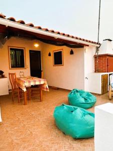 un patio con tavolo, sedie e una casa di Casa dos AVÓS a Santana de Cambas
