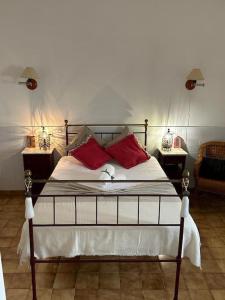 - une chambre avec un lit doté d'oreillers rouges dans l'établissement Casa dos AVÓS, à Santana de Cambas