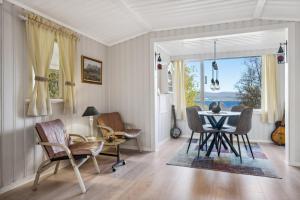 a dining room with a table and chairs and a window at Hytte i Saltstraumen in Bodø