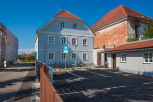 a blue building with a parking lot in front of it at Apartmani Kac in Karlovac