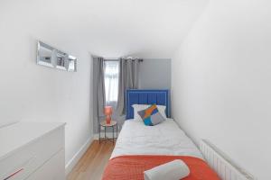 a bedroom with a blue and white bed and a window at The Marsden - Modern 3 bed, Virgin TV, WIFI in Edmonton