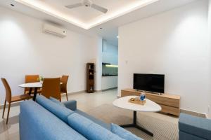 Una sala de estar con un sofá azul y un televisor. en Tin Tin Apartment, en Ho Chi Minh