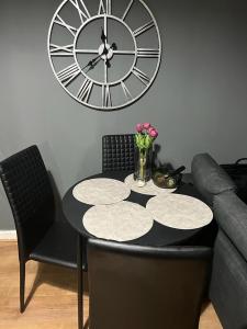 a table and chairs with a large clock on the wall at City center in Manchester