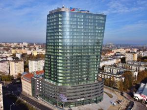 a tall glass building in the middle of a city at Hanza Tower - Luxurious Apartment 60m2 - 15th Floor City View in Szczecin
