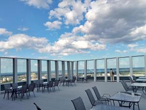 a patio with tables and chairs on a roof at Hanza Tower - Luxurious Apartment 60m2 - 15th Floor City View in Szczecin