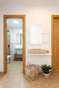 a bathroom with a sink and a basket on the floor at 123 Sotavento Beach and Sun By Sunkeyrents in La Tejita