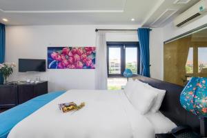 Un dormitorio con una gran cama blanca y una ventana en Thanh Binh Riverside Hoi An en Hoi An